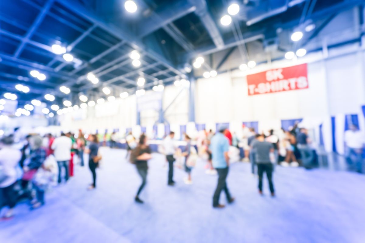 Blurred abstract crowd of people in conventional hall/expo event fair to pickup running t-shirt 5K, 10K, half, full marathon race in Houston, Texas, US. Fitness, healthy lifestyle concept background.